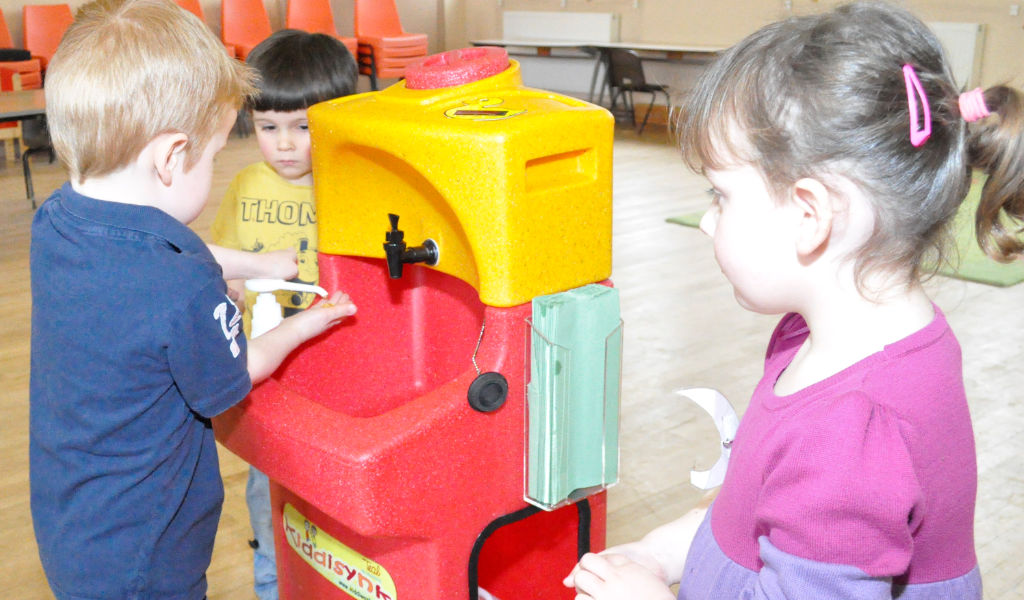 Children learning to wash hands with a KiddiSynk at a preschool