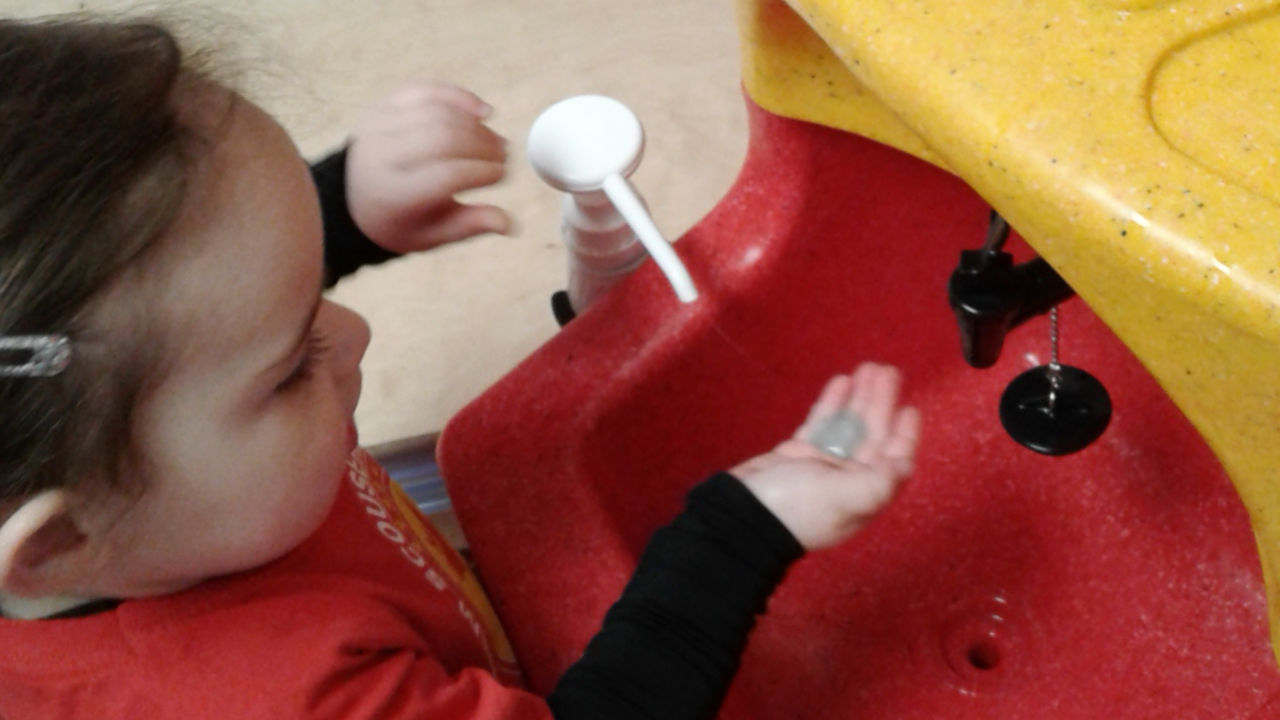 A child washing hands with a KiddiSynk