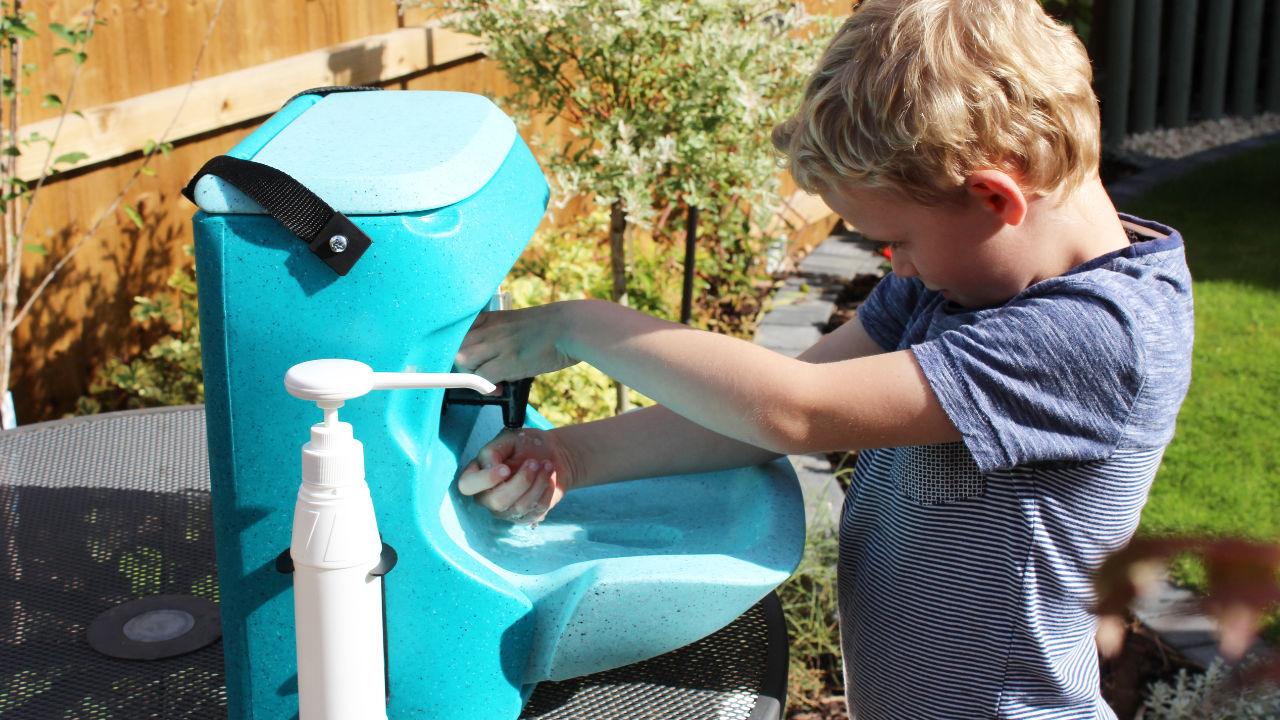 A KiddiWash Xtra portable handwash sink being used out of doors