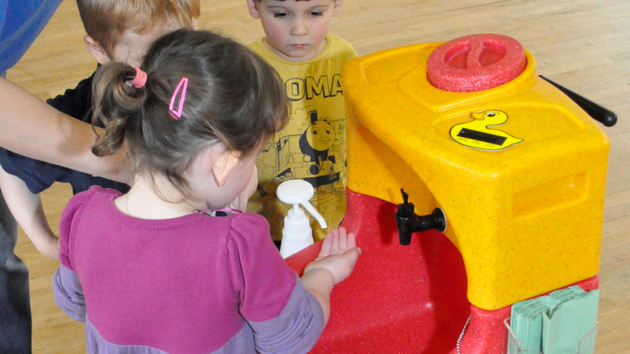 Preschool children learning to wash their hands with a KiddiSynk