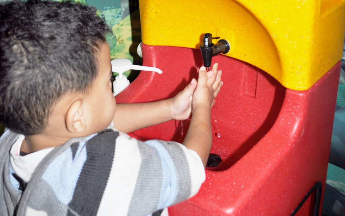 A child washing hands with a KiddiSynk mobile sink